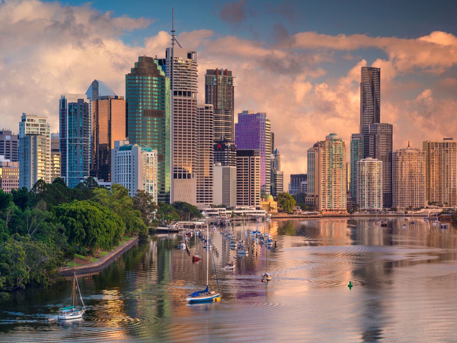 en bysilhuett med båter i vannet foran den, Brisbane
