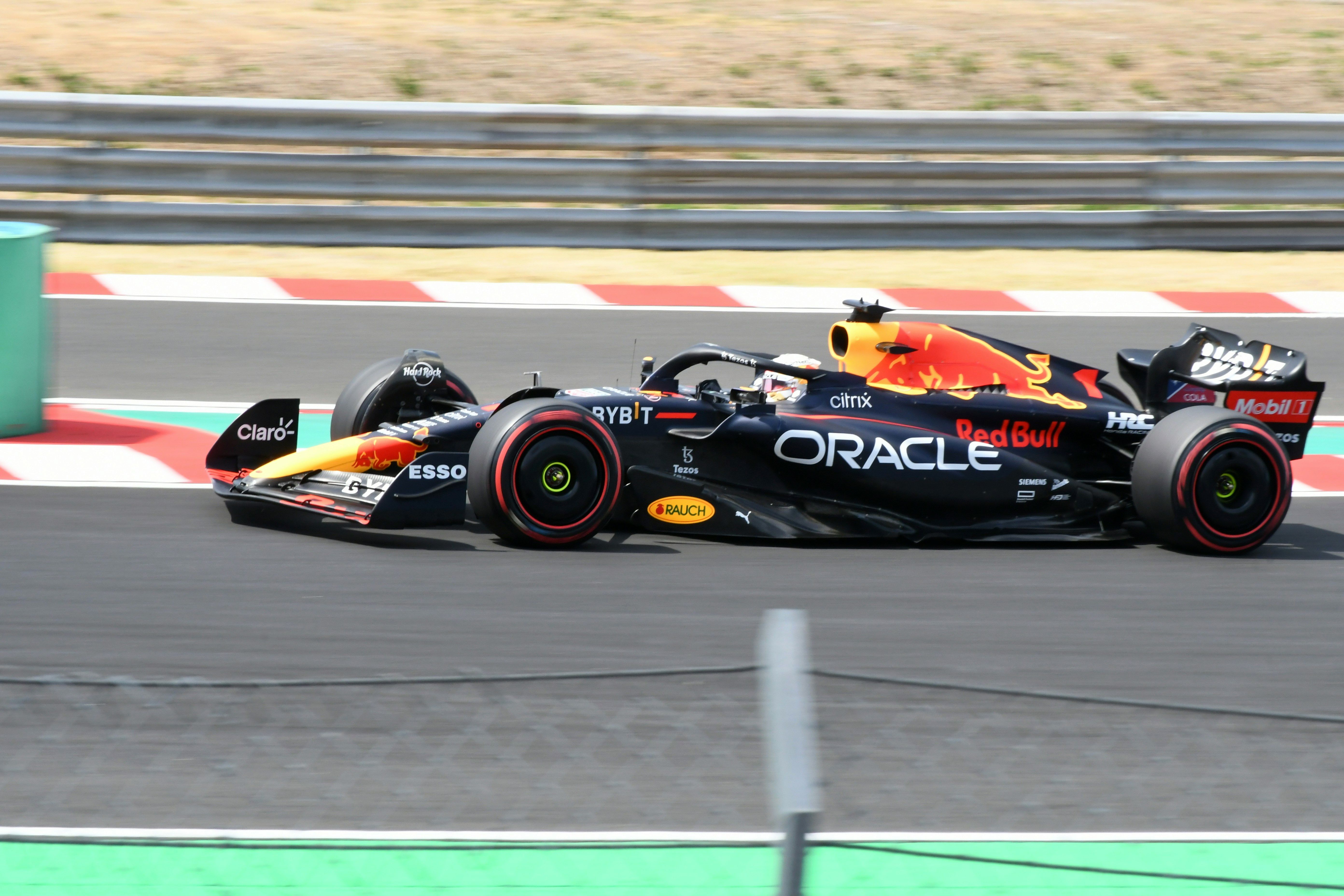 A black and red Red Bull Formula 1 car speeding on a race track.