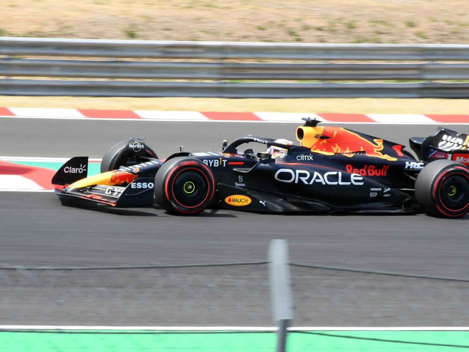 A black and red Red Bull Formula 1 car speeding on a race track.