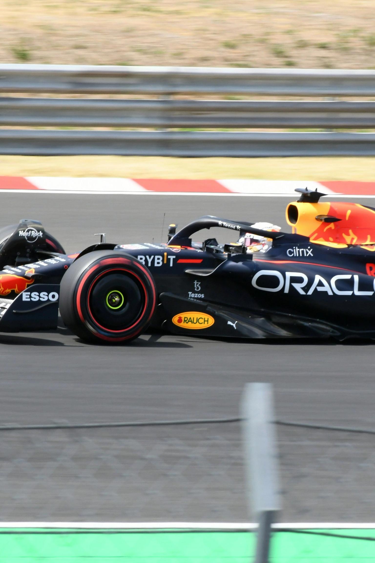 A black and red Red Bull Formula 1 car speeding on a race track.