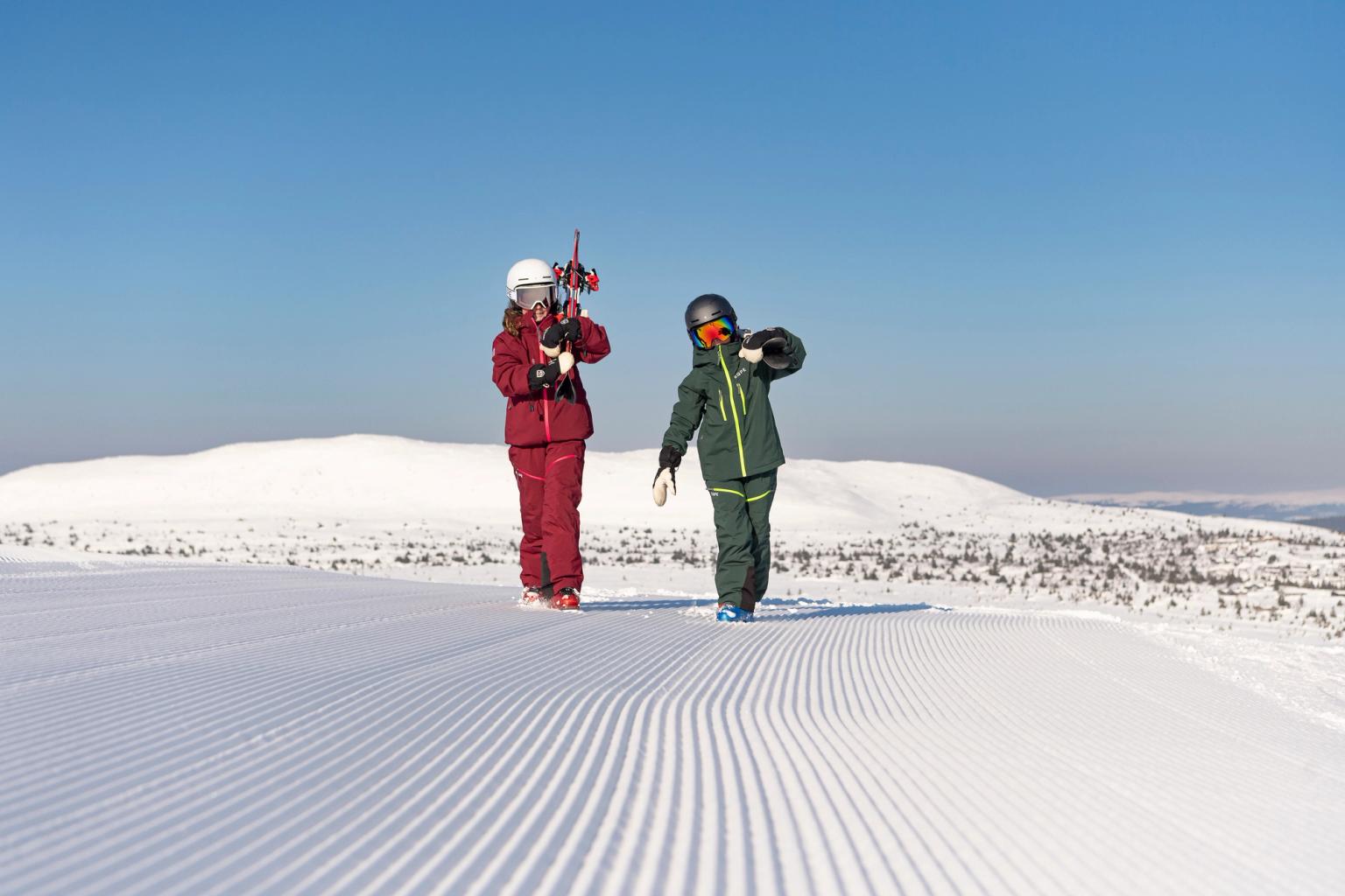 to personer står på toppen av en snødekket bakke