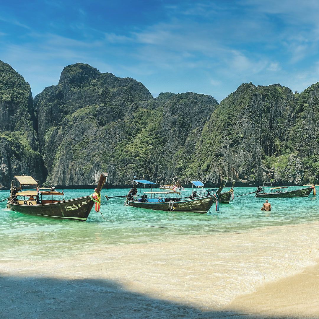 en gruppe både flyder oven på en sandstrand.