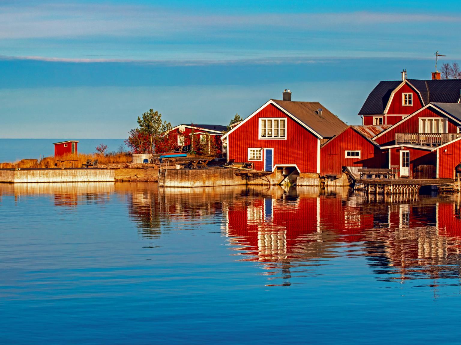 en gruppe røde huse, der sidder på toppen af et vandområde