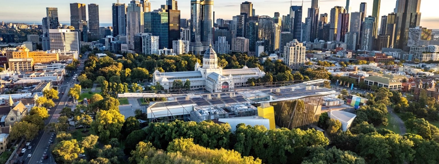 en flygvy över en stadssilhuett med en tennisbana i förgrunden, Melbourne