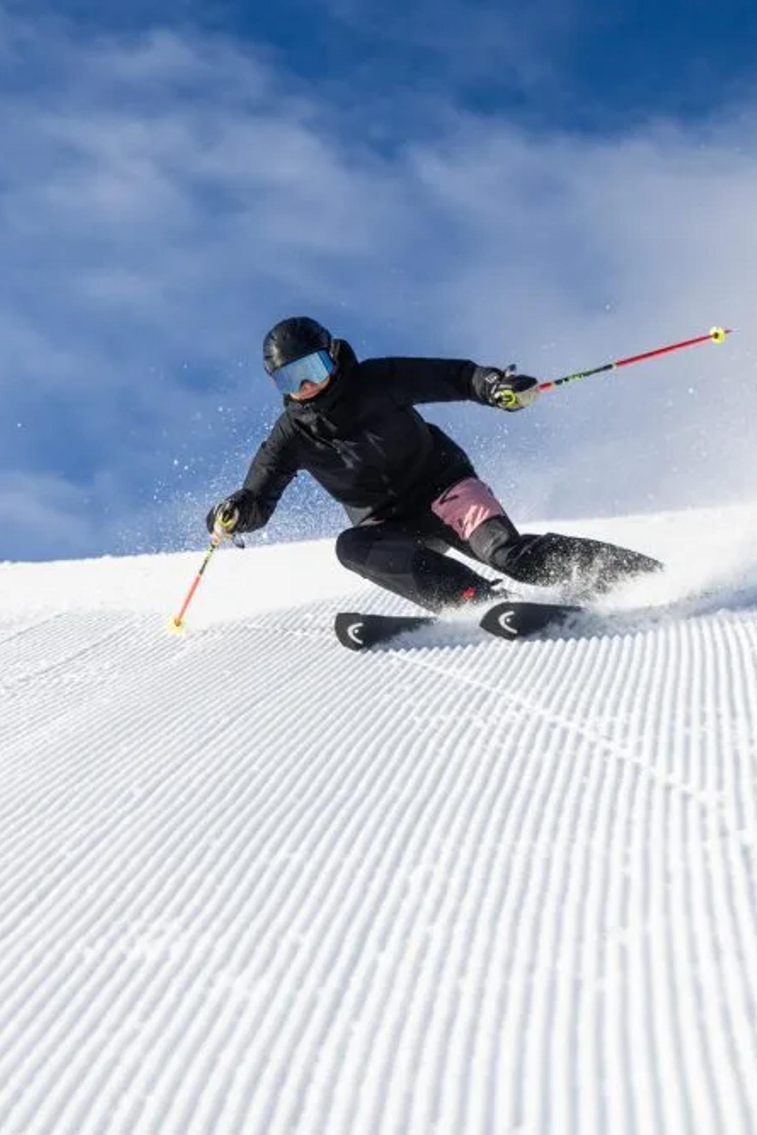 en person står på ski ned en snødekket bakke