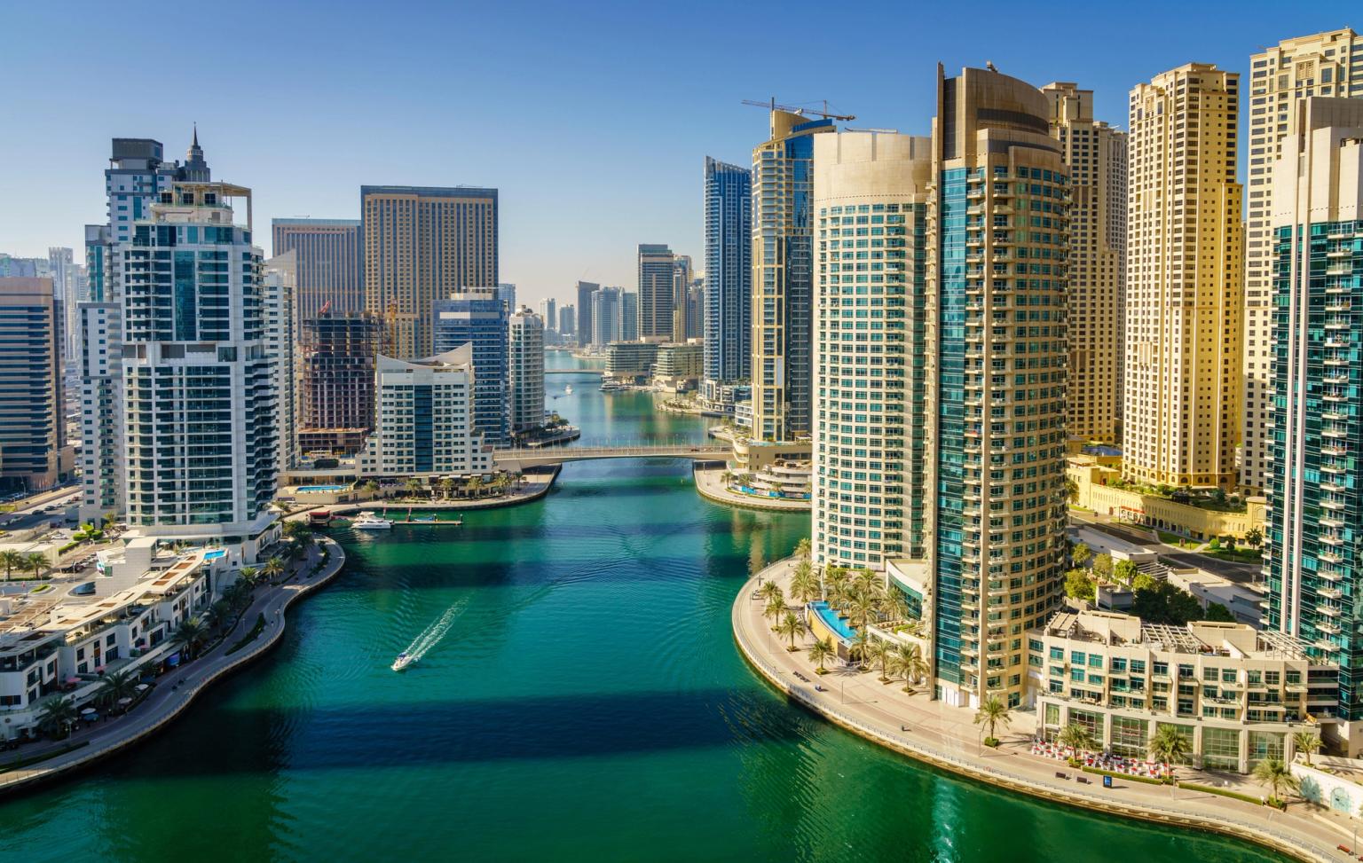 et luftfoto av Dubai med en vannmasse omgitt av høye bygninger