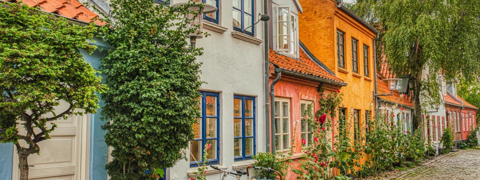 en sykkel er parkert foran en rekke fargerike hus på en brosteinsbelagt gate