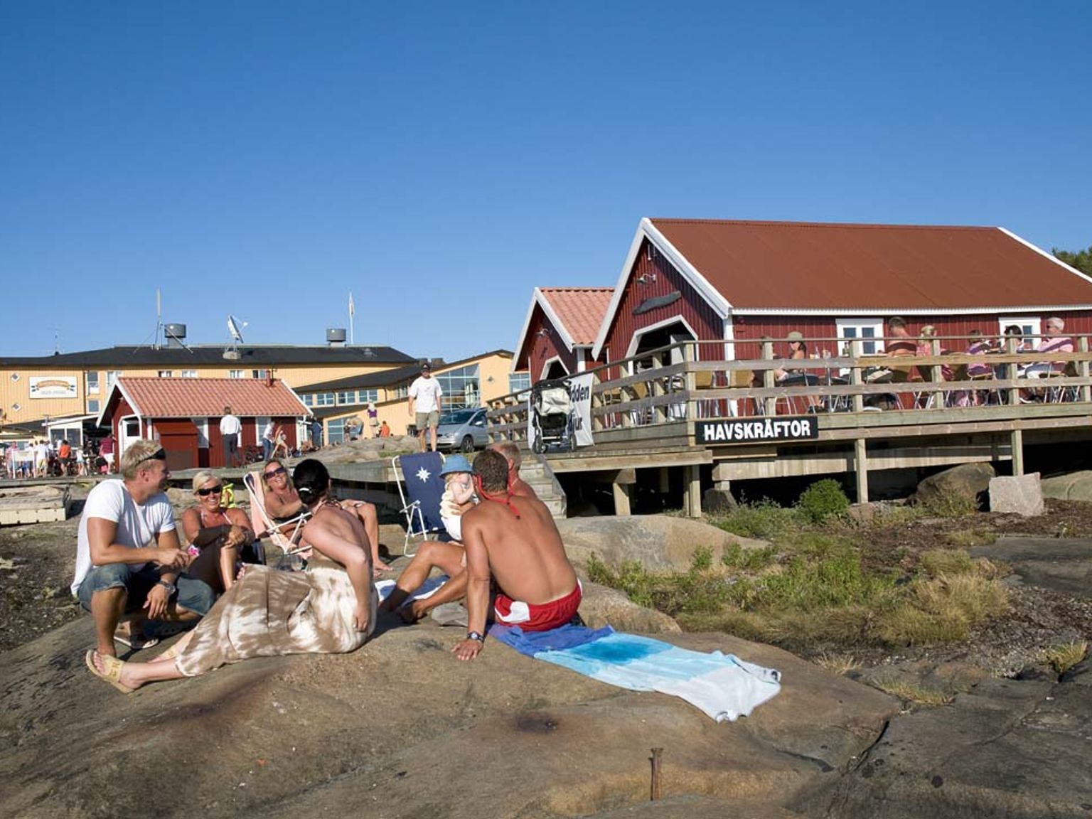 eine Gruppe von Menschen sitzt auf einem Felsen am Strand
