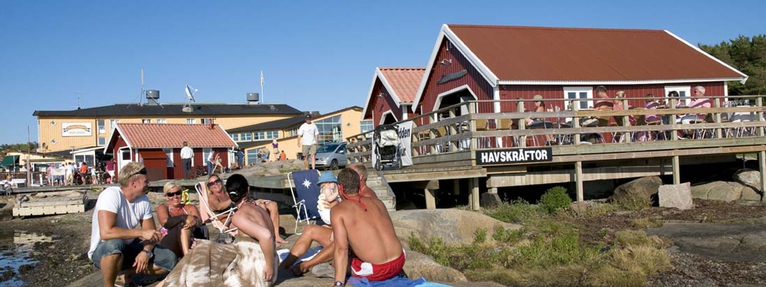eine Gruppe von Menschen sitzt auf einem Felsen am Strand