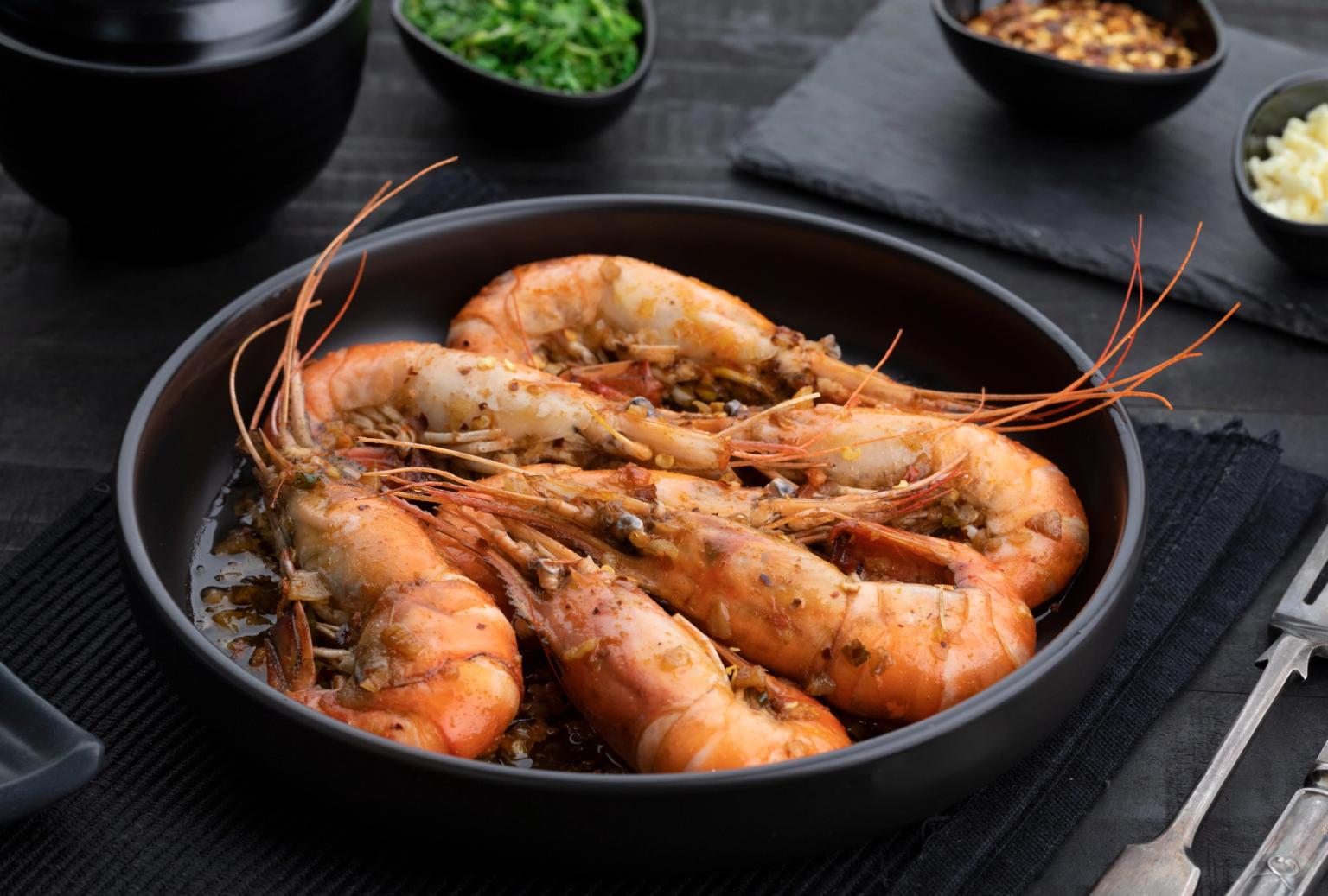 shrimp are being cooked in a pan on a table