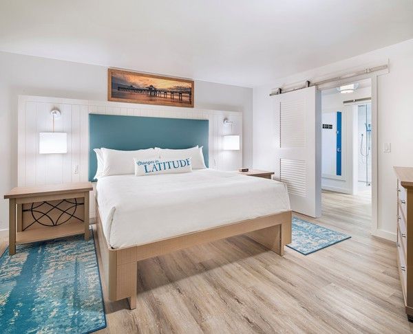 et hotellrom med en king size seng, nattbord og en kommode.