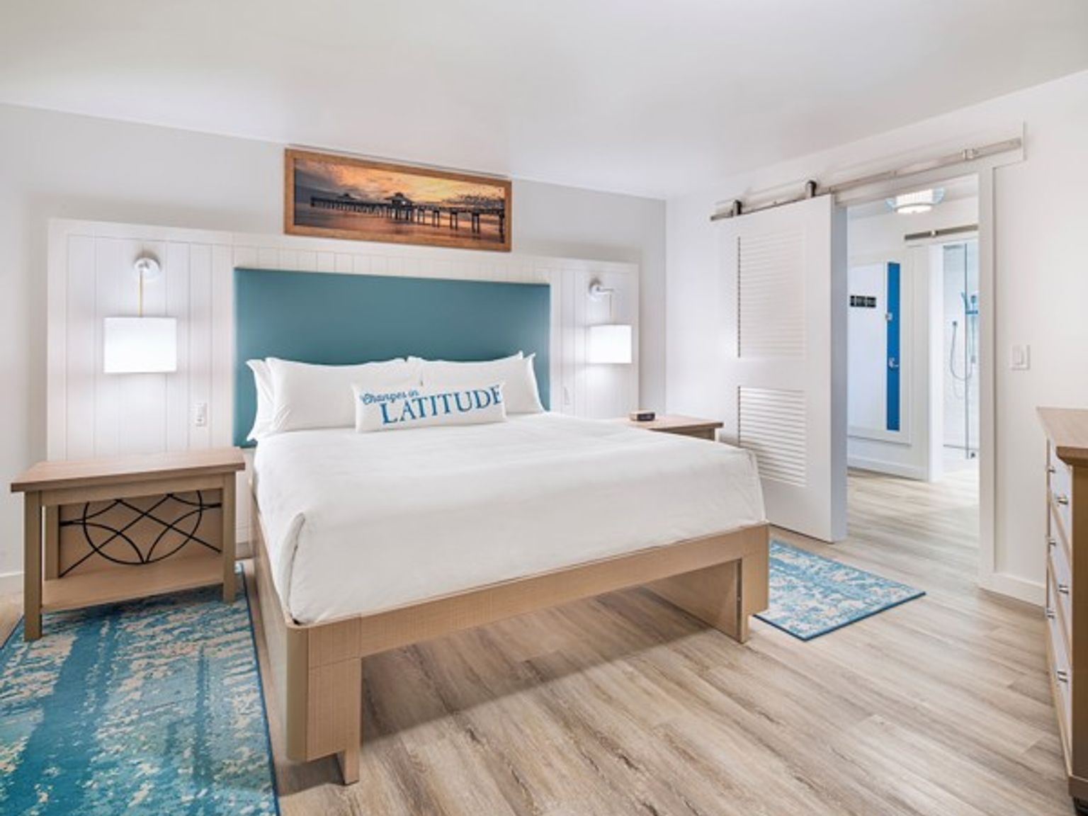 et hotellrom med en king size seng, nattbord og en kommode.