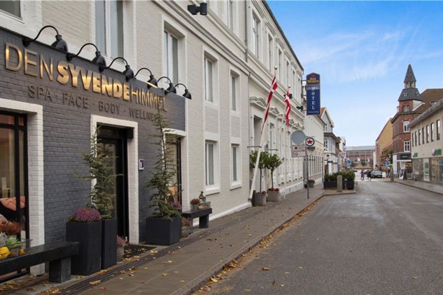 en stor byggnad med en skylt på den ligger på sidan av en stadsgata