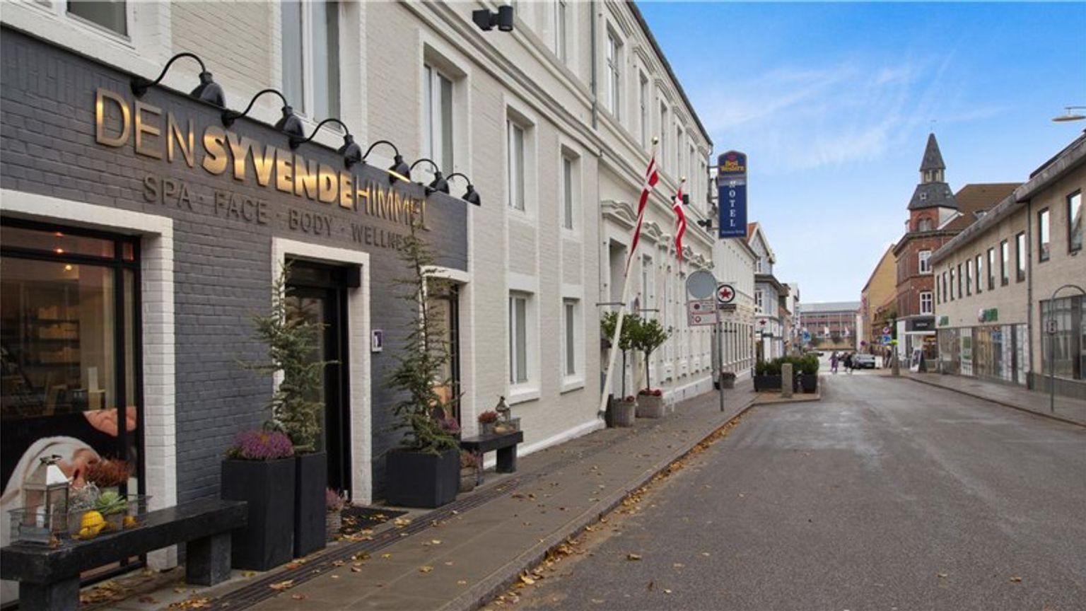 en stor byggnad med en skylt på den ligger på sidan av en stadsgata