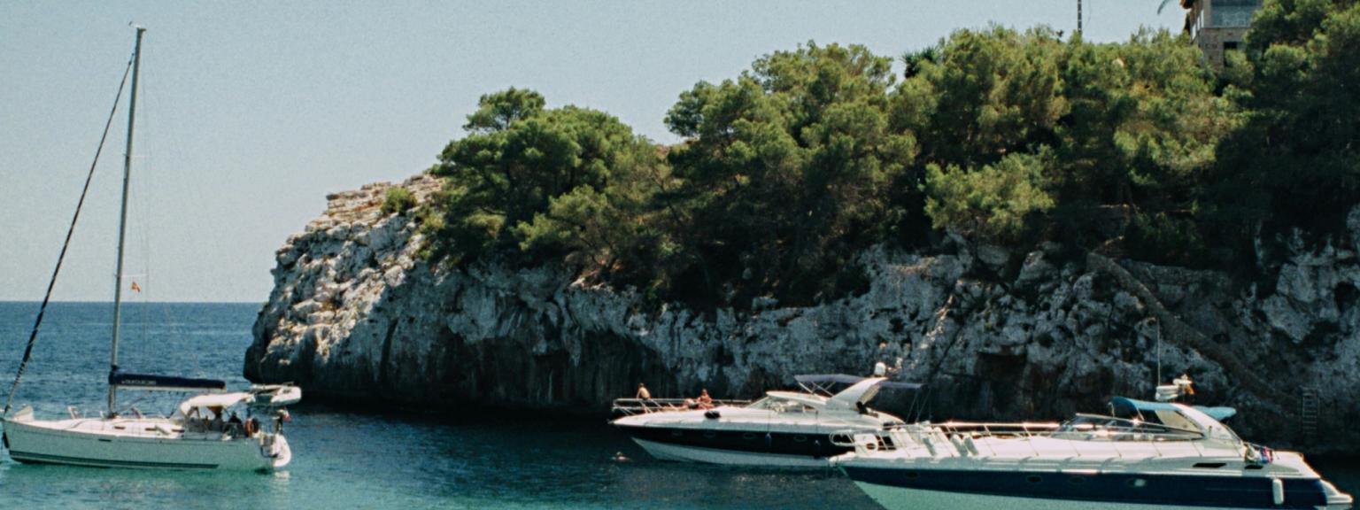 ett par bÄtar Àr i vattnet nÀra en klippa