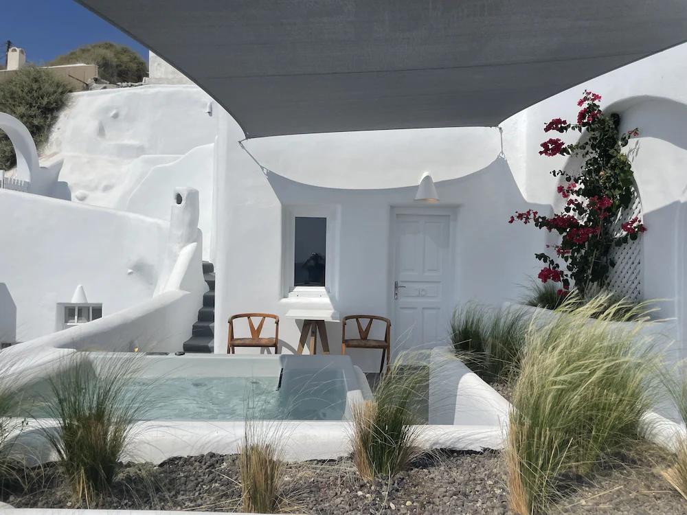 det er et boblebad i bakgården til en hvit bygning.