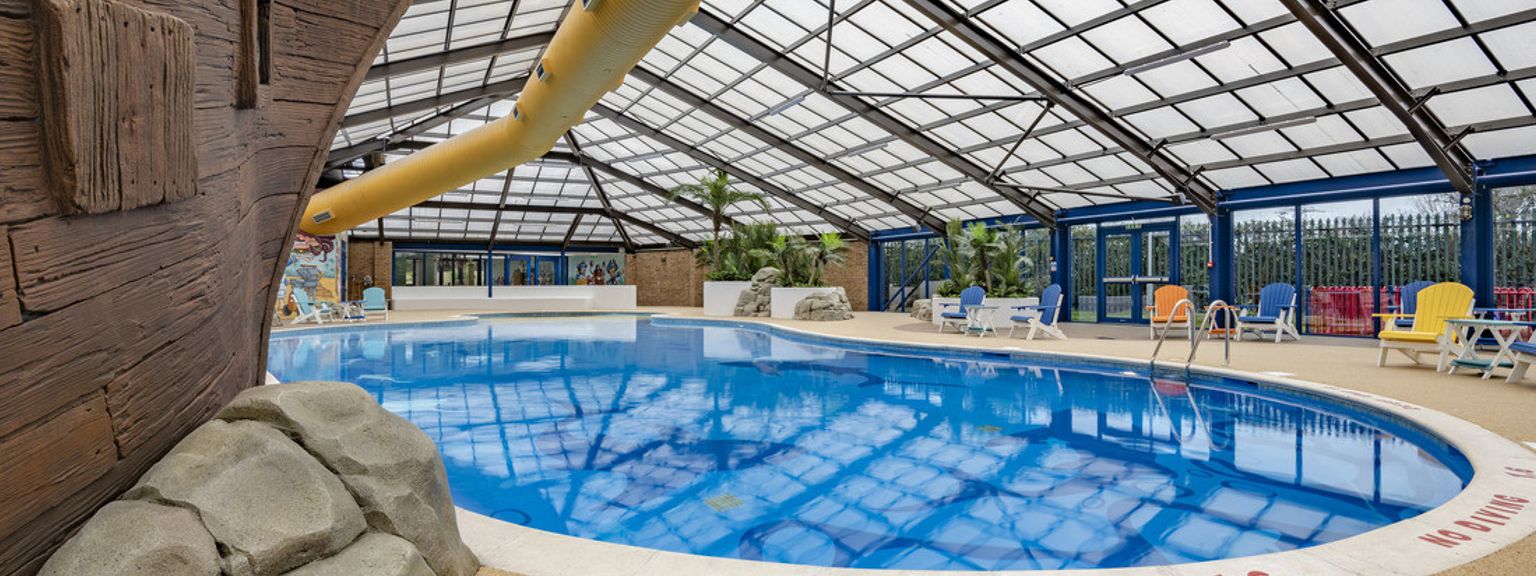 a large indoor swimming pool with a pirate ship in the background