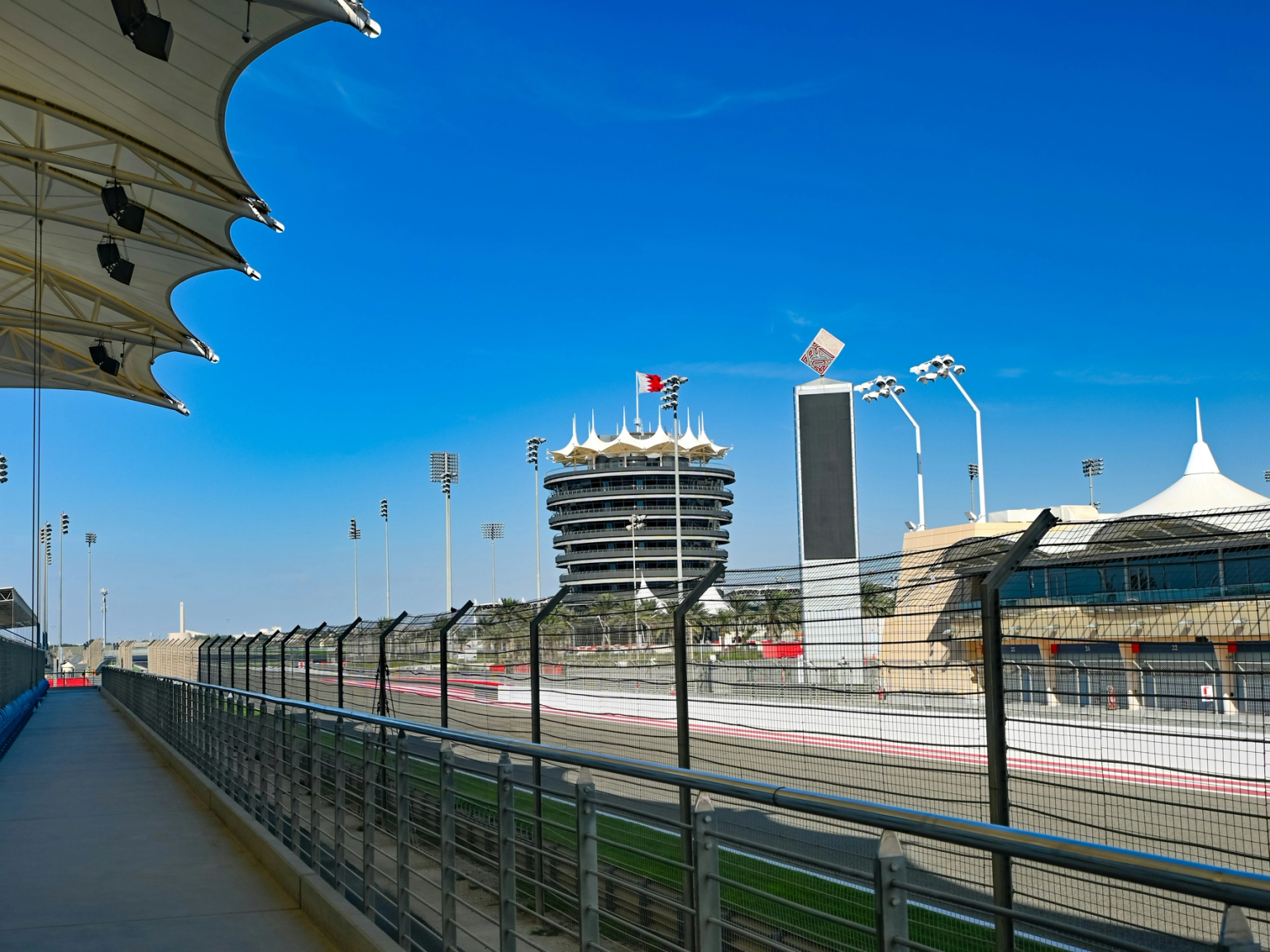 Bahrain International Circuit -kilparata tunnusomaisine torneineen ja katsomoineen kirkkaan sinisen taivaan alla.
