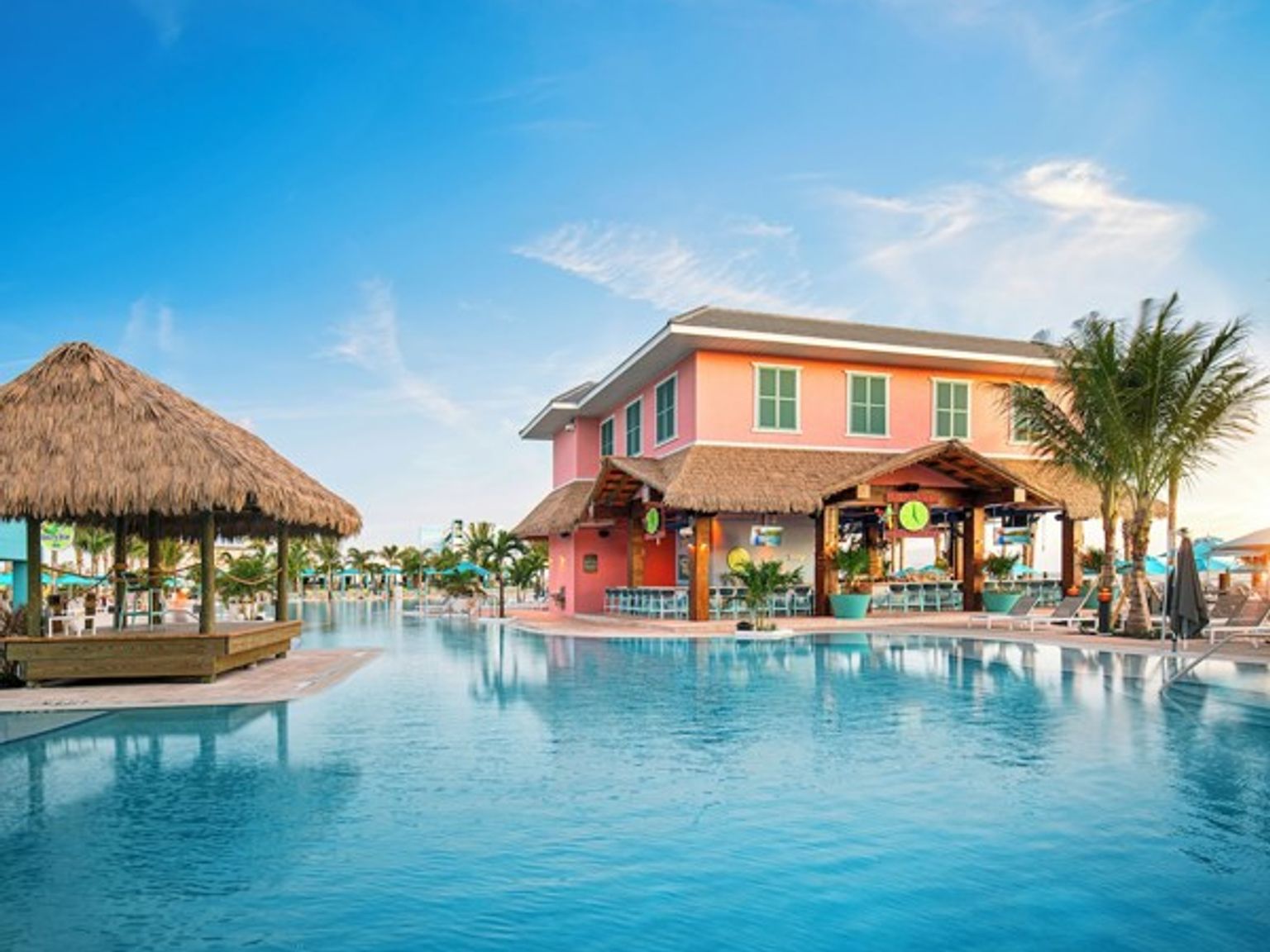 et stort svømmebasseng med en fargerik bygning i bakgrunnen.