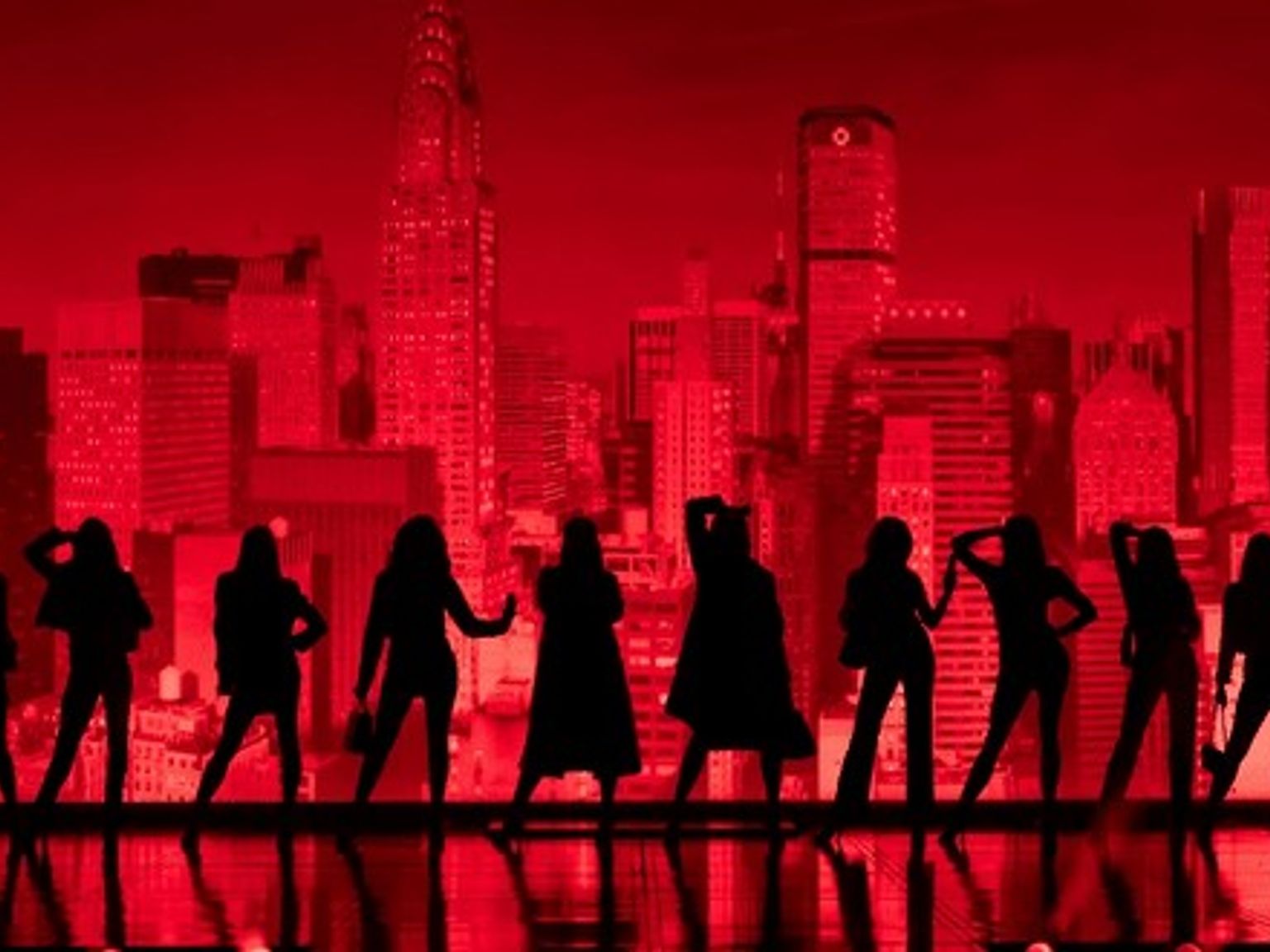 Eleven silhouetted figures pose on a reflective floor in front of a red city skyline.