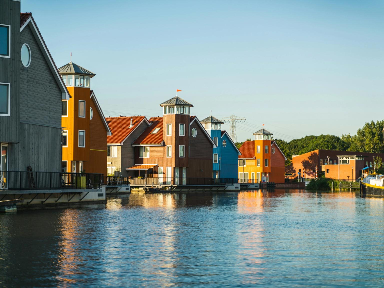 a row of colorful houses sitting next to a body of water