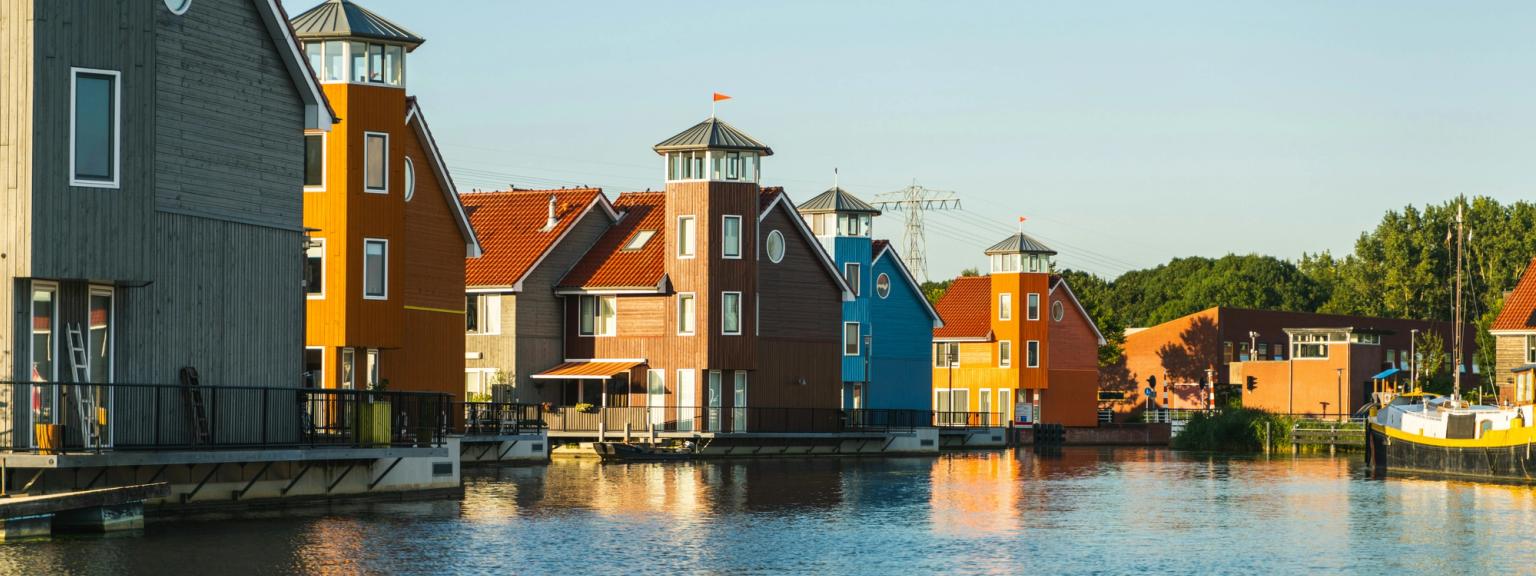 a row of colorful houses sitting next to a body of water