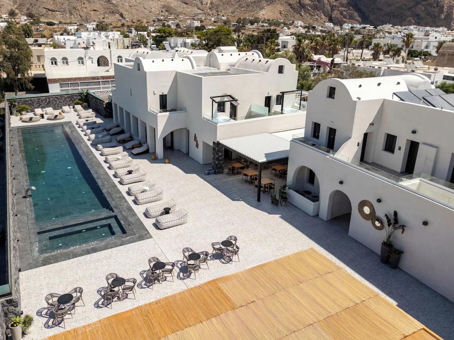 et luftfoto af et hotel med en stor swimmingpool og borde og stole