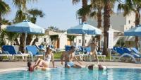 En familj med två barn njuter av en solig dag vid en resorts pool.
