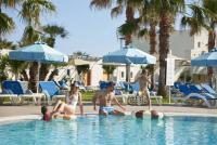 En familj med två barn njuter av en solig dag vid en resorts pool.