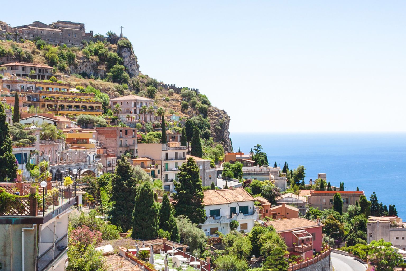 en flygvy av Taormina på en kulle med utsikt över havet