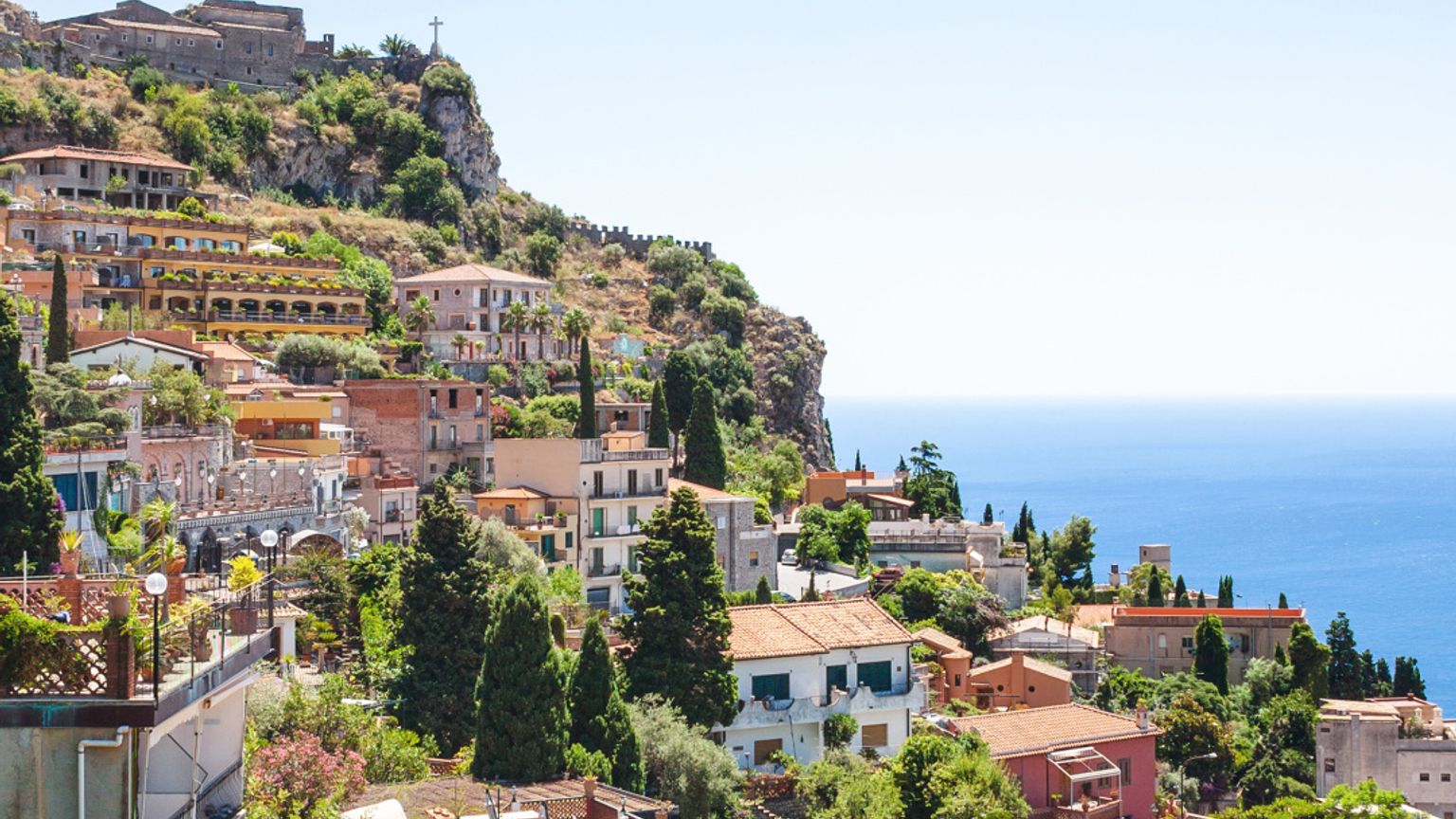 en flygvy av Taormina på en kulle med utsikt över havet