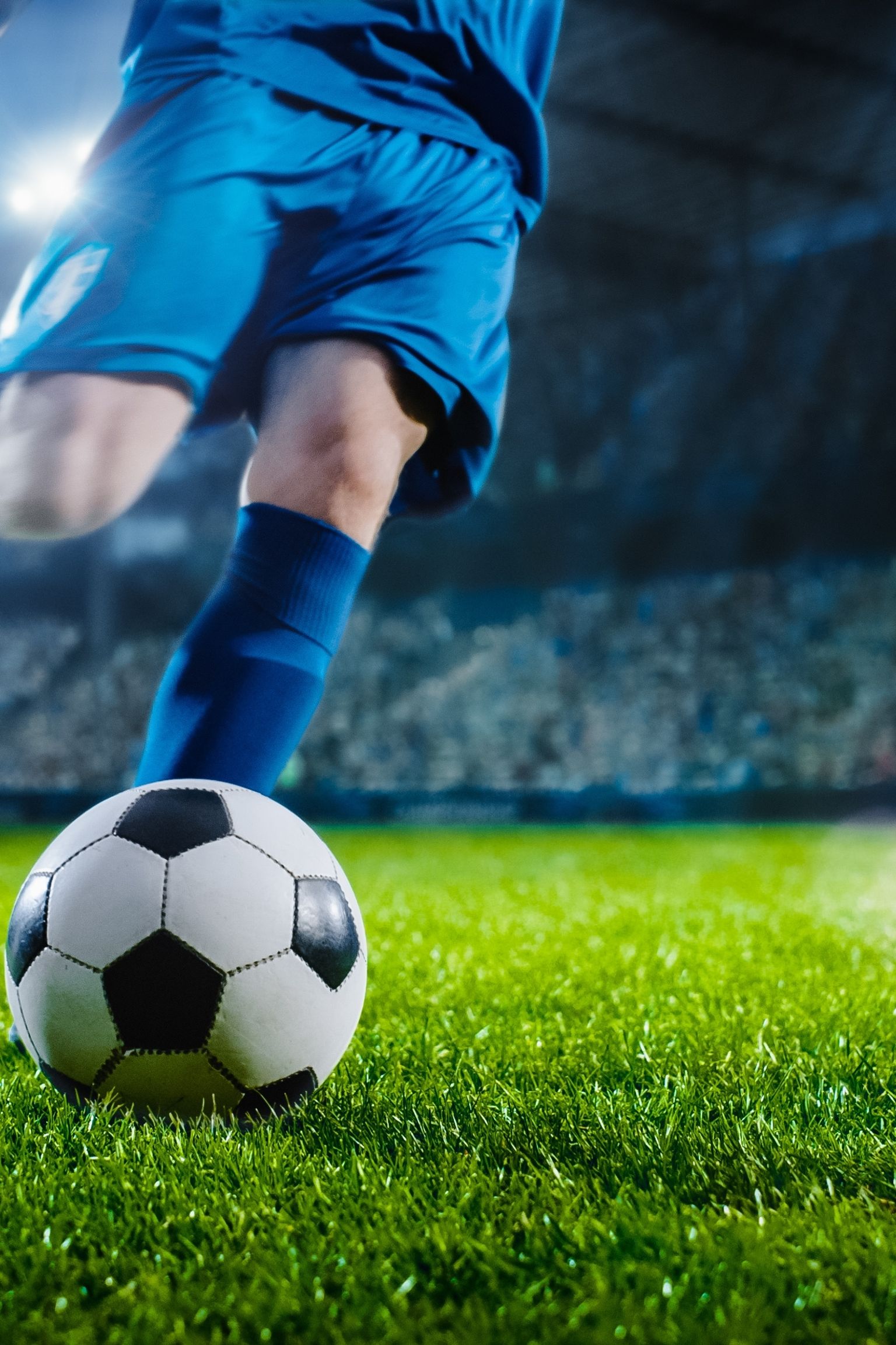 un joueur de football donne un coup de pied dans un ballon sur un terrain