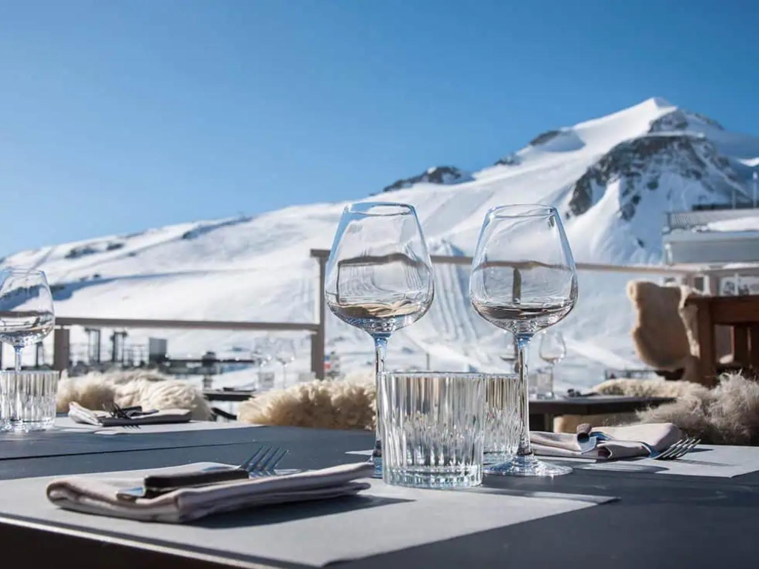et bord dekket for et måltid med et fjell i bakgrunnen, Hôtel Les Suites - Maison Bouvier, Tignes