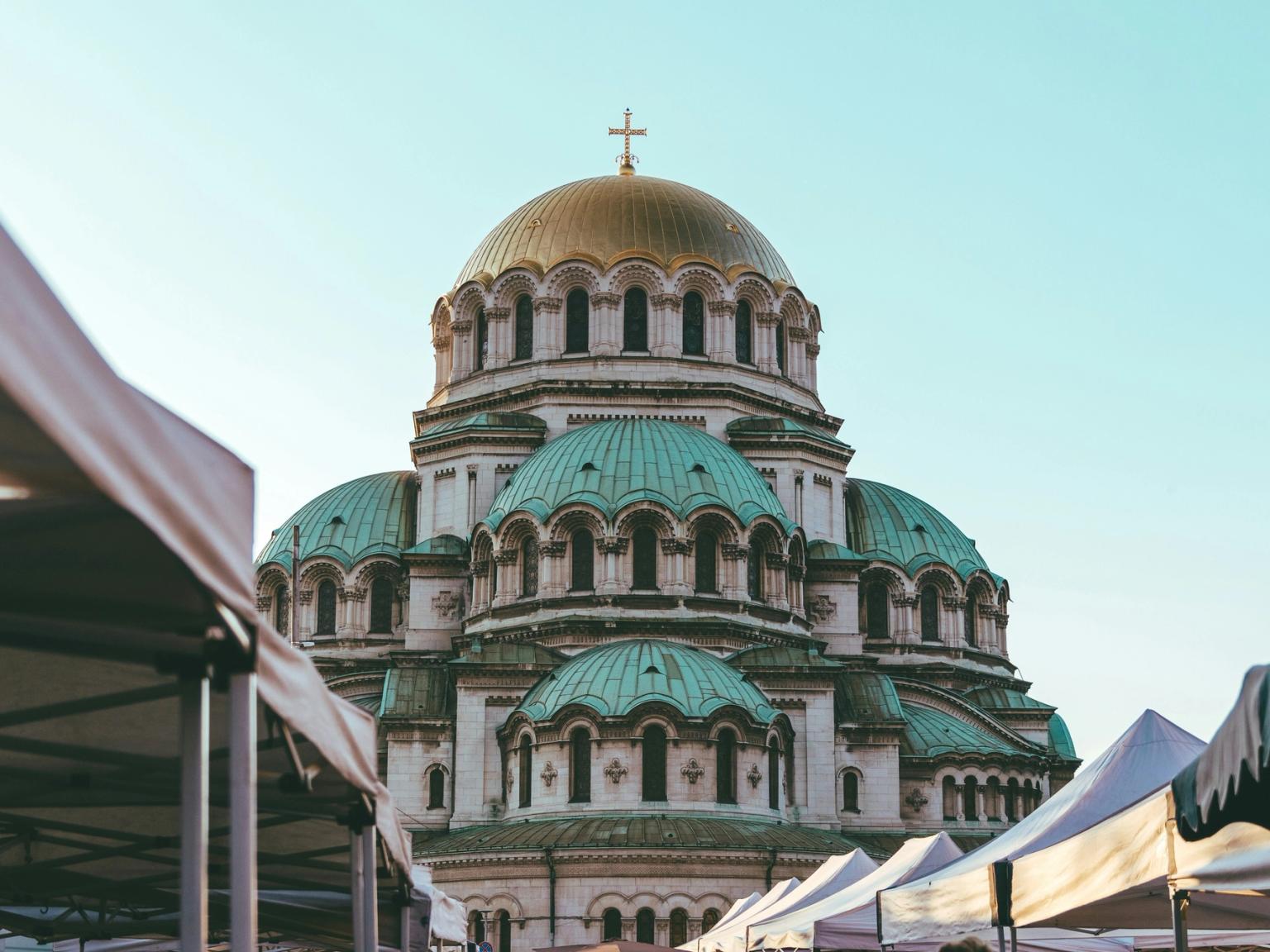 en stor kyrka med en kupol och ett kors på toppen av det är omgiven av tält