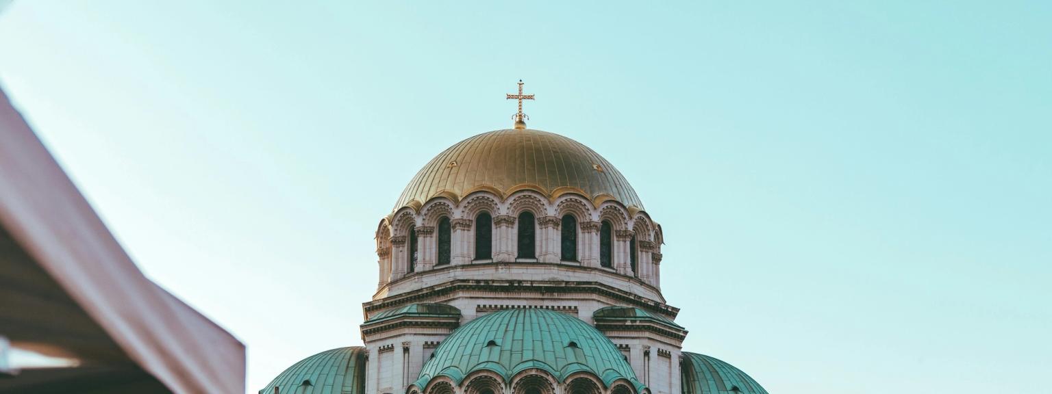 en stor kyrka med en kupol och ett kors på toppen av det är omgiven av tält