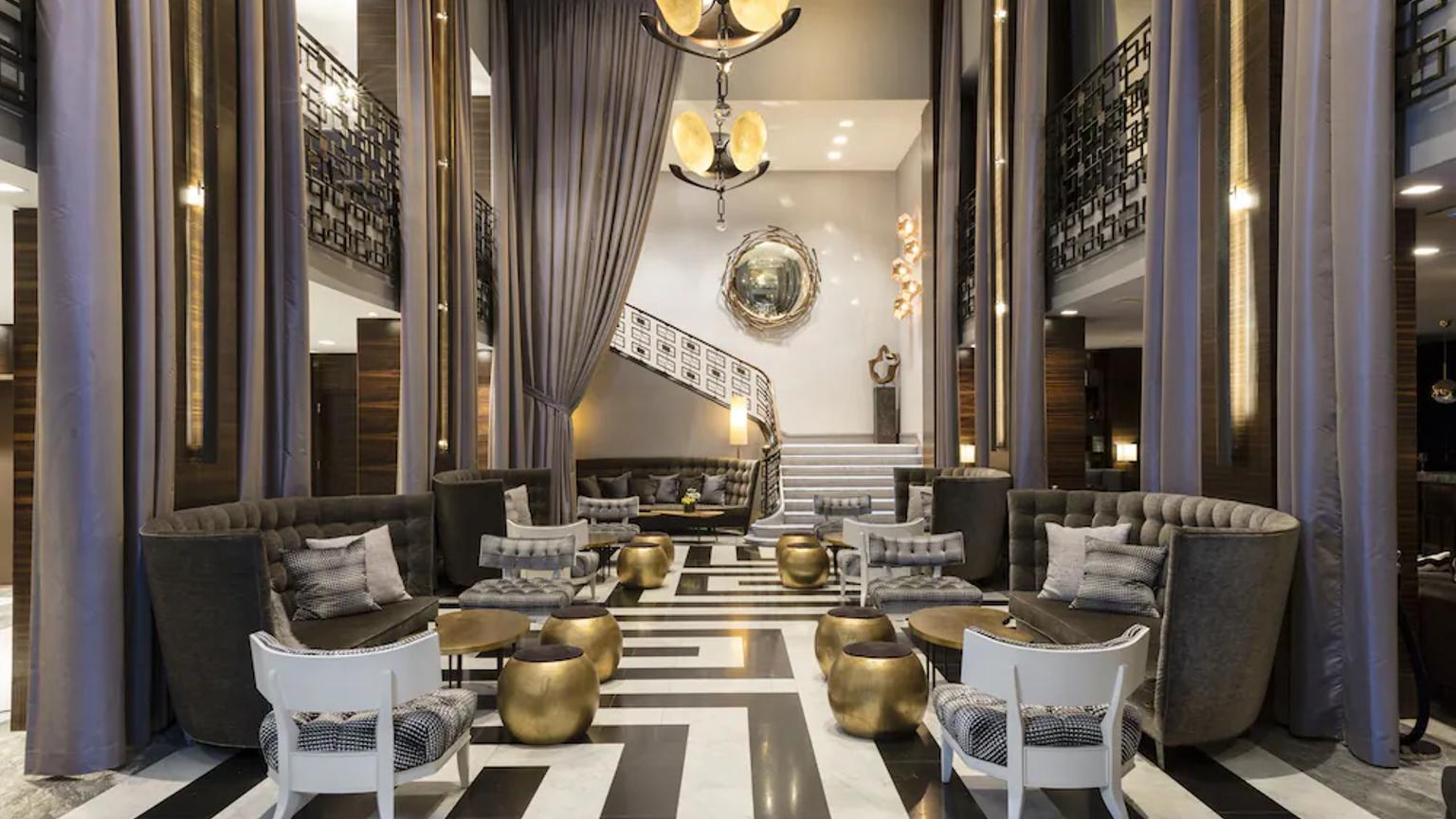 lobbyen av et hotell med et svart og hvitt stripet gulv og en lysekrone