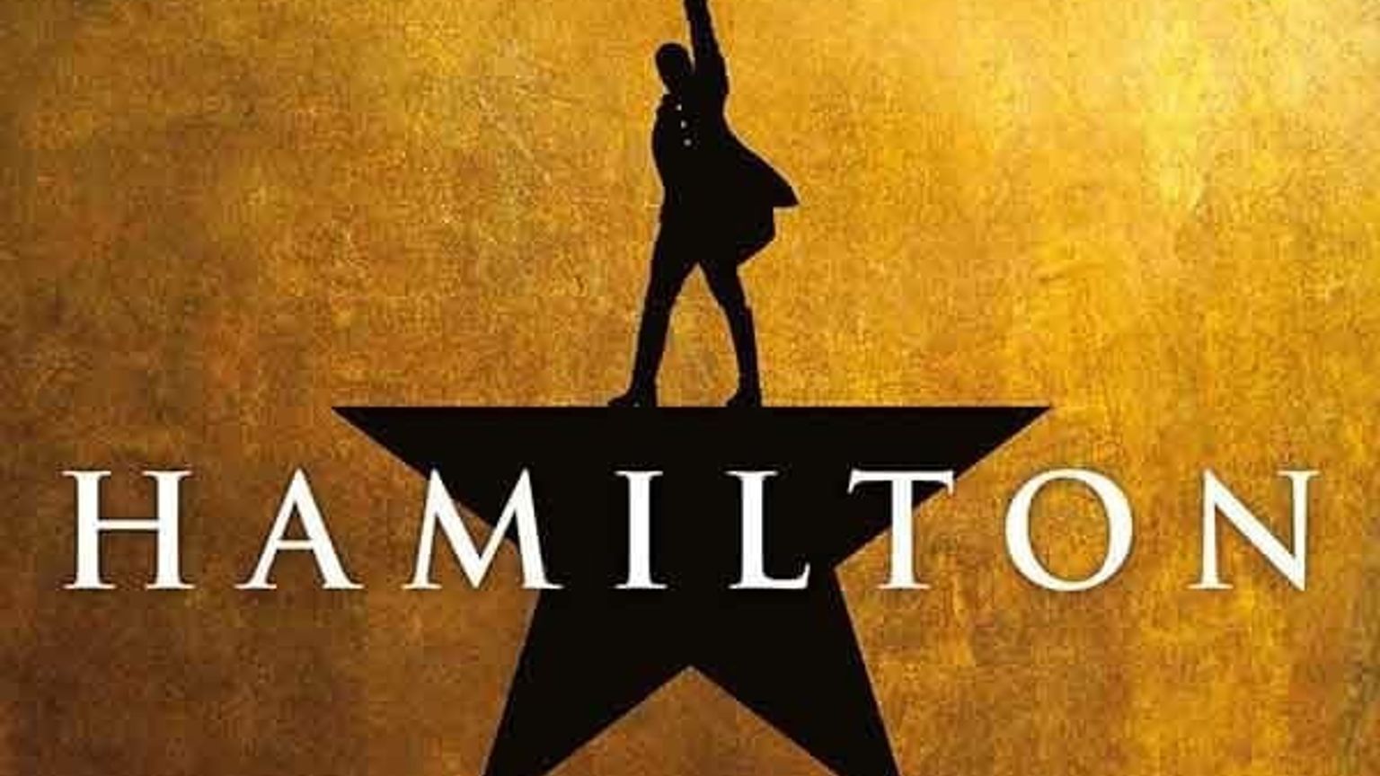 Svart silhuett av en mann som står på en stjerne med en arm hevet, med ordet HAMILTON under, mot en teksturert gyllen bakgrunn. Musikaler - Hamilton - London