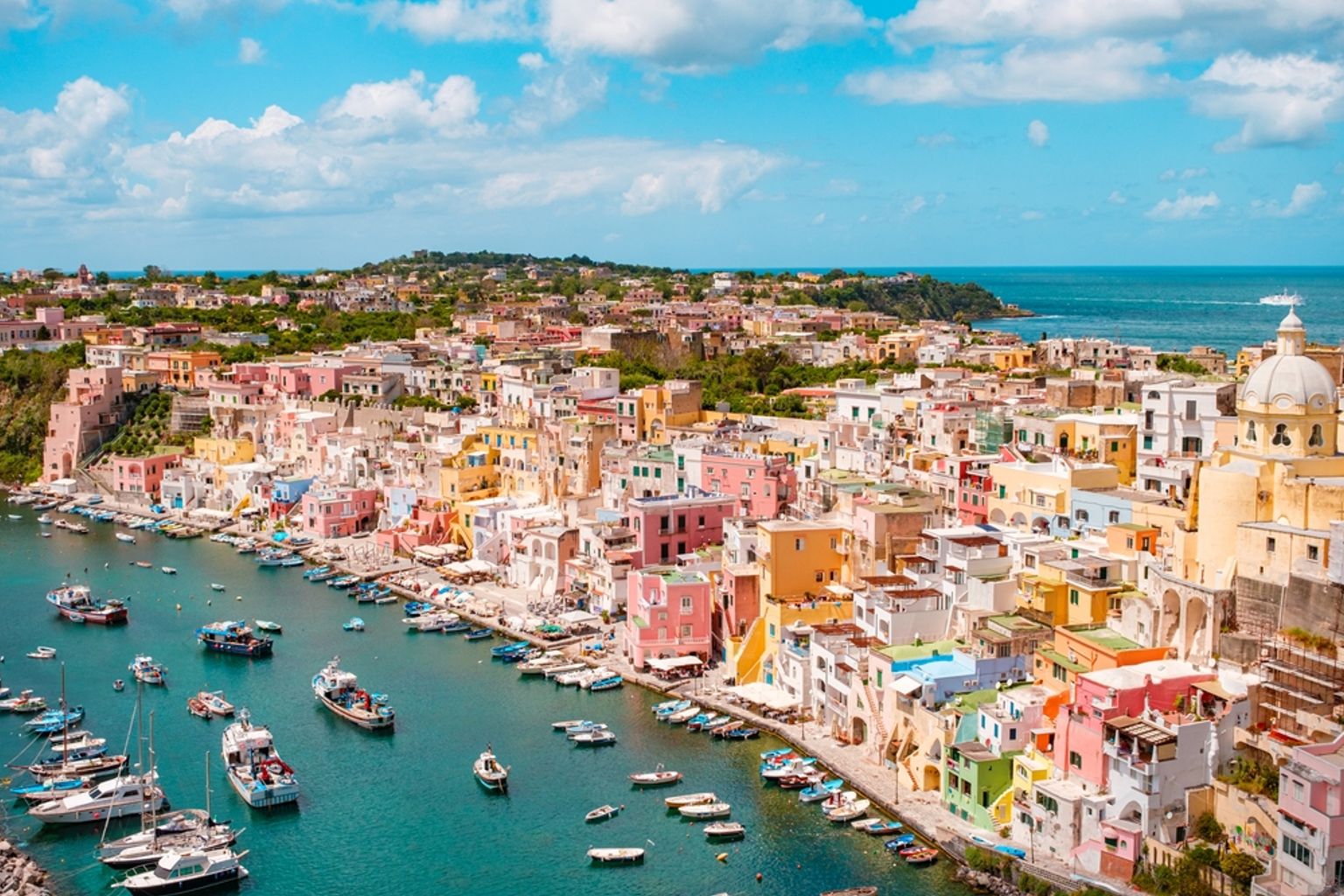 Vue aérienne d’une ville côtière animée avec des bâtiments colorés autour d’un port rempli de bateaux. Procida, Italie