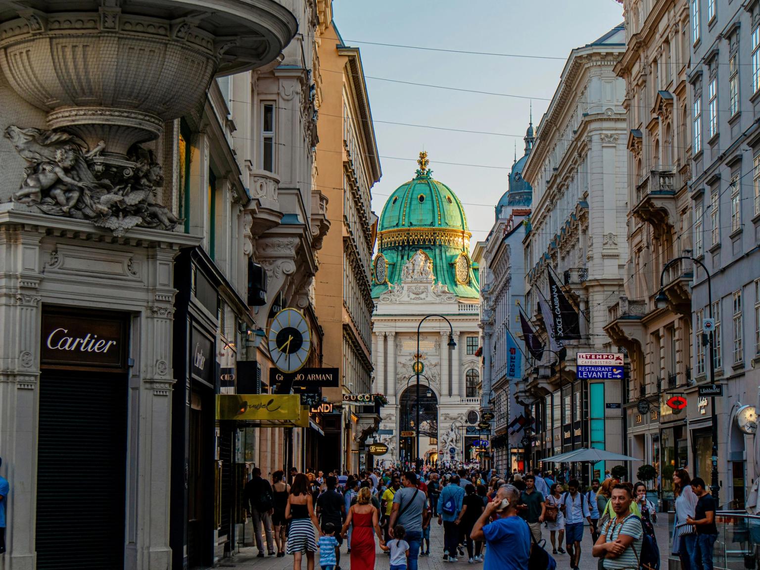 en folkmassa går nerför en livlig stadsgata i Wien