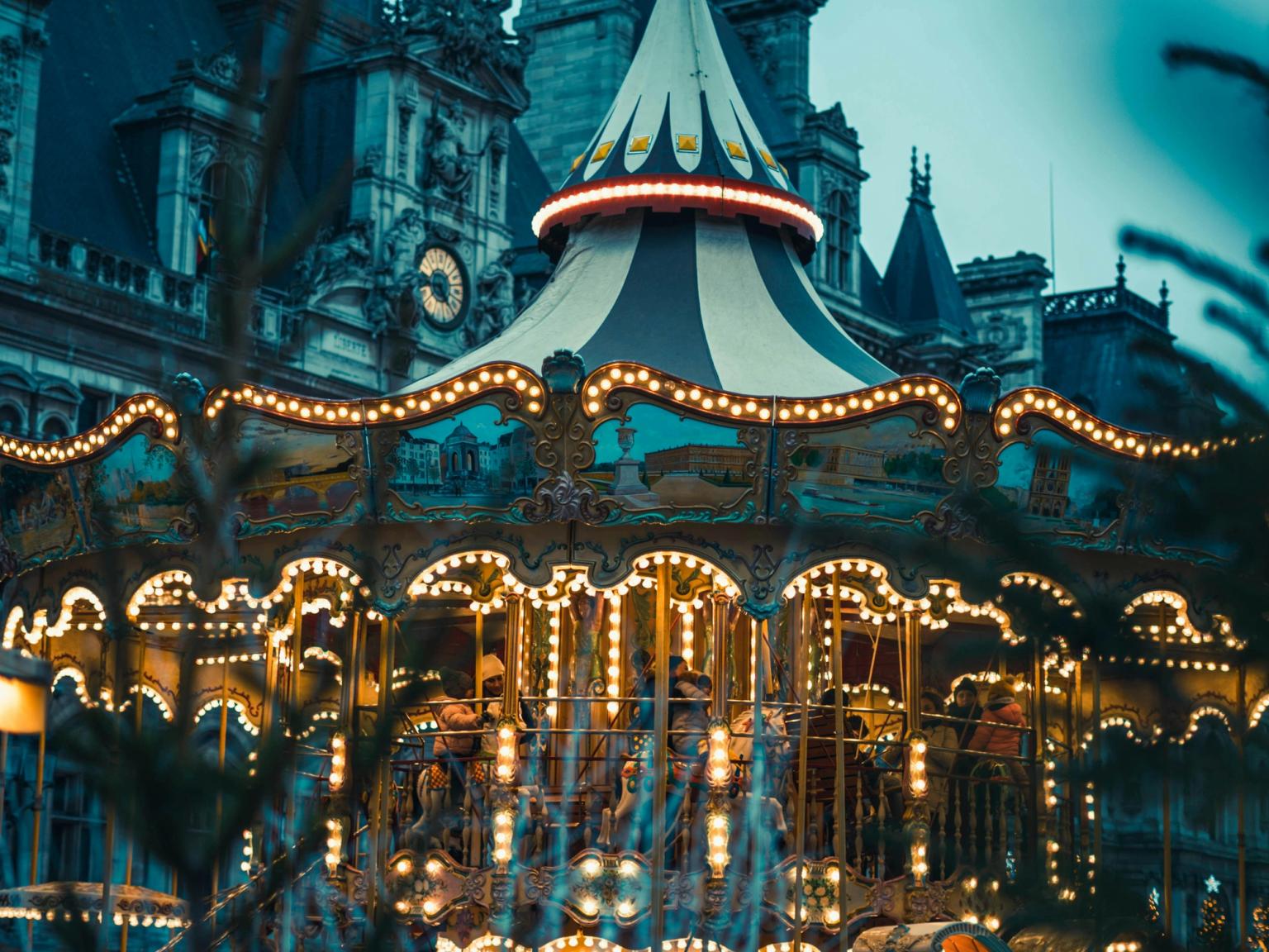 en karusell är upplyst framför en byggnad, Disneyland Paris