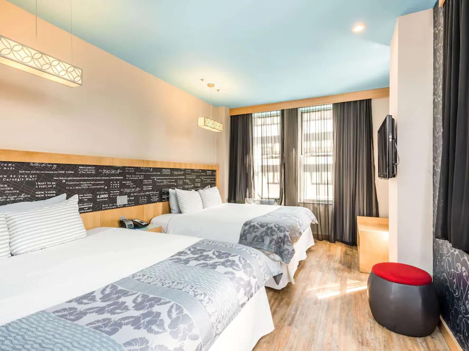 et hotellrom med to senger og en fjernsyn