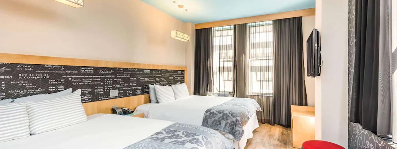 ett hotellrum med två sängar och en television