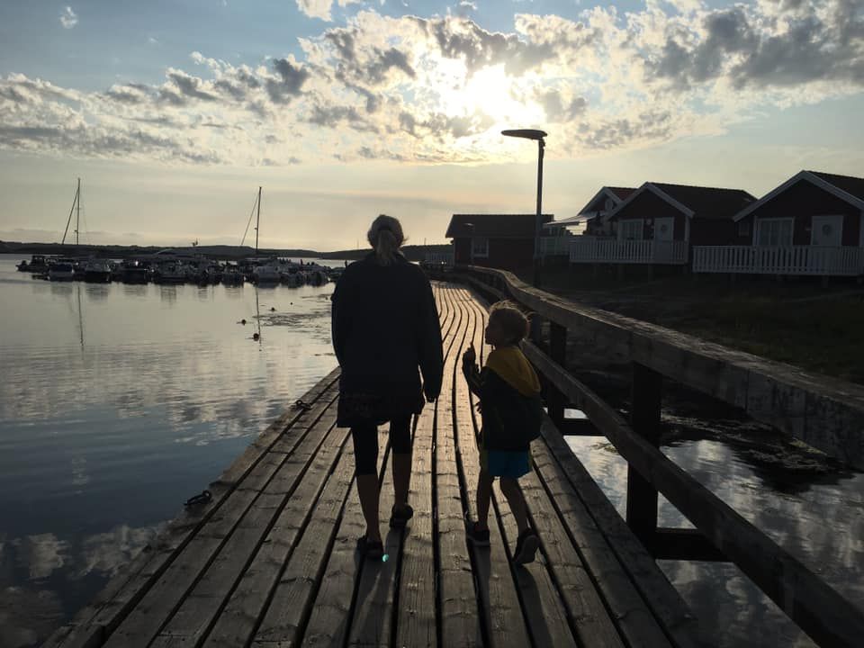 en kvinne og et barn går over en trebrygge