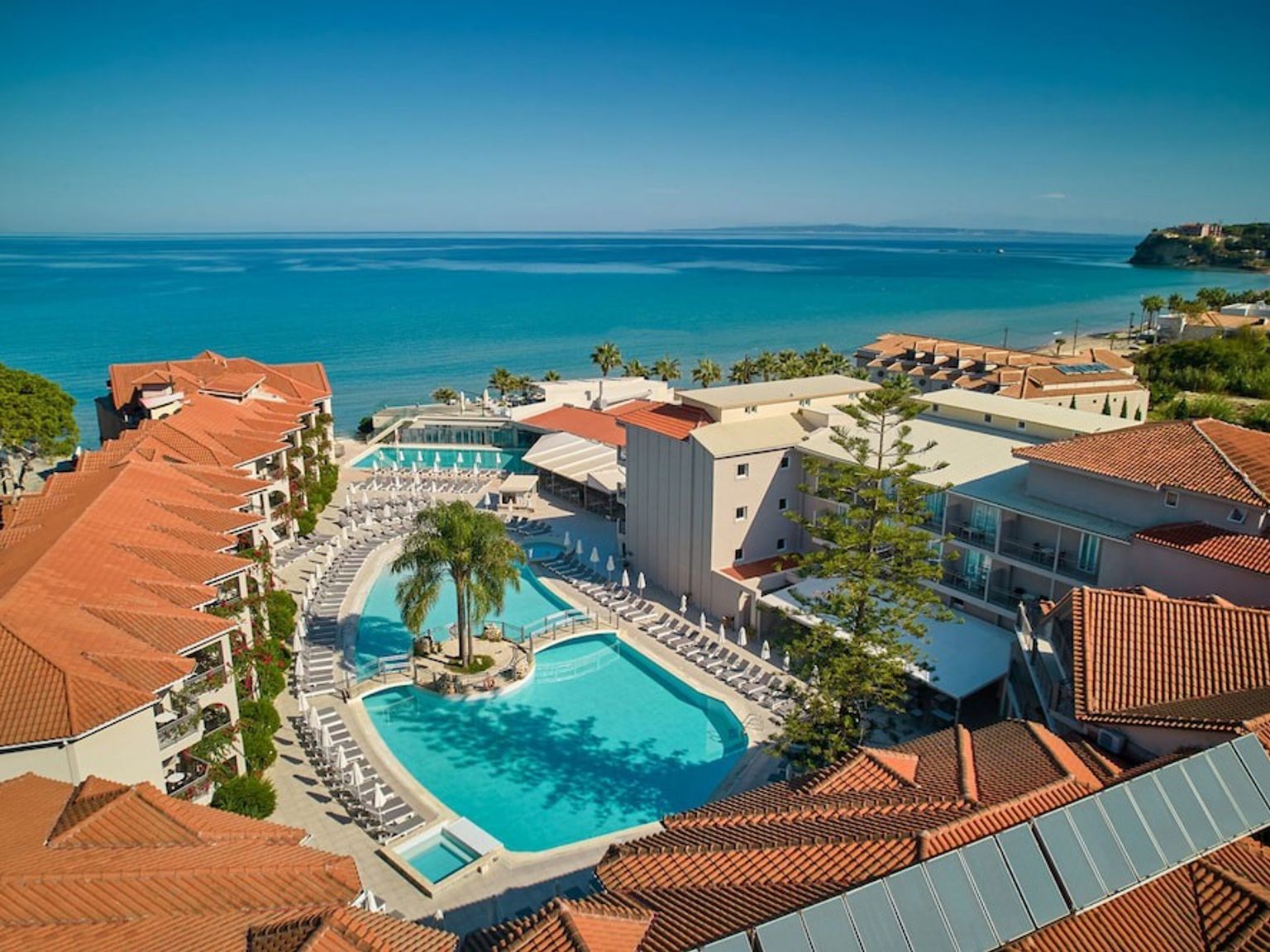 en flygvy av ett hotell med en stor swimmingpool och en strand.