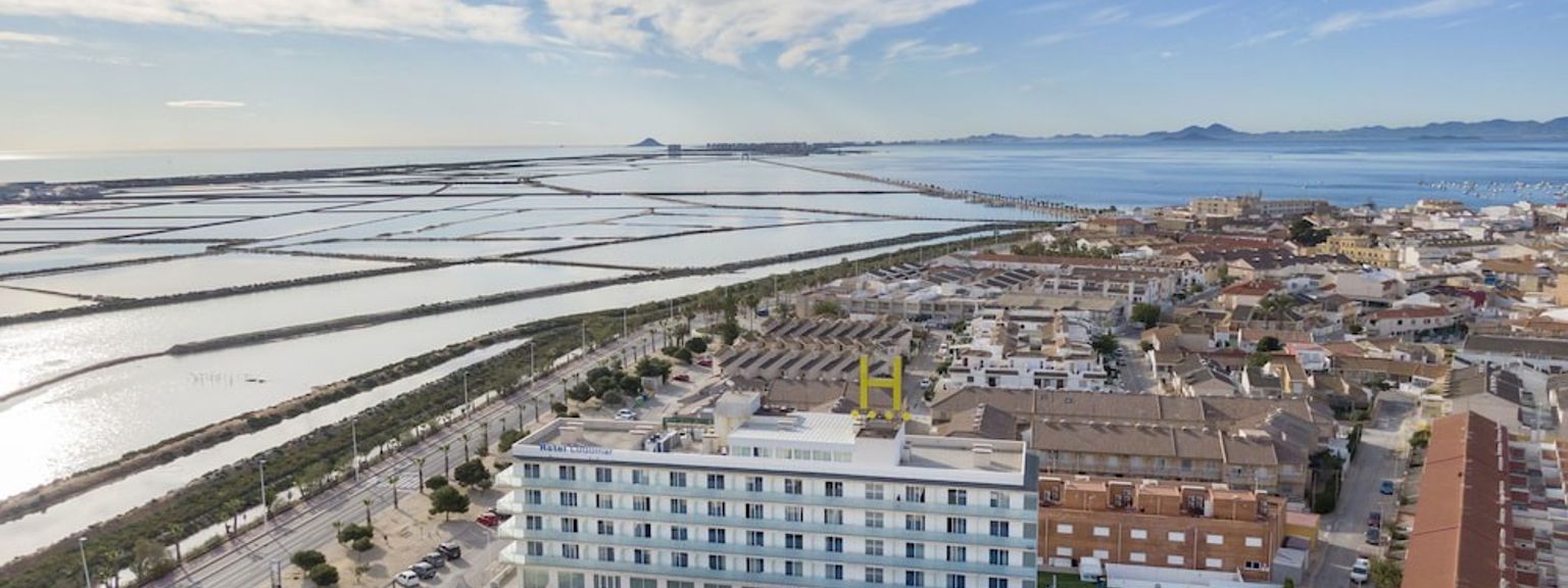 en luftig utsikt over en stor bygning ved siden av et vann