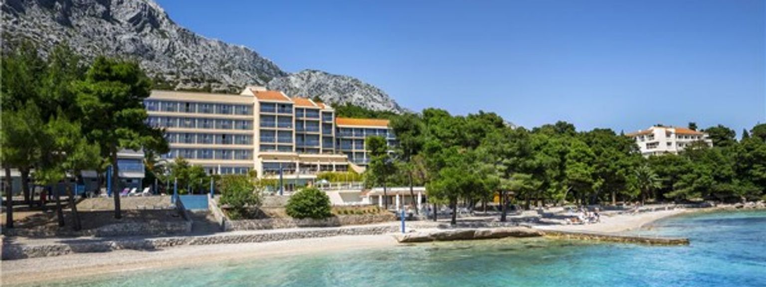 ett stort hotell ligger vid stranden av en strand bredvid havet