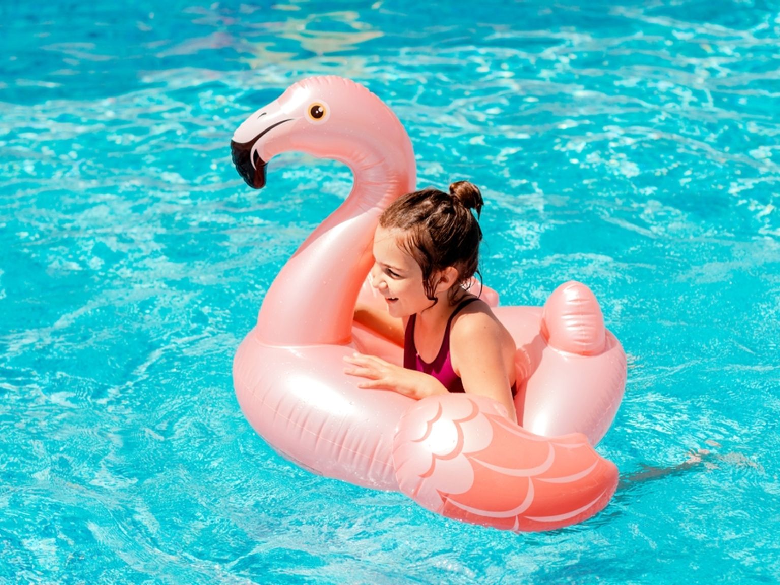 Dziewczyna w różowym flamingu do pływania.