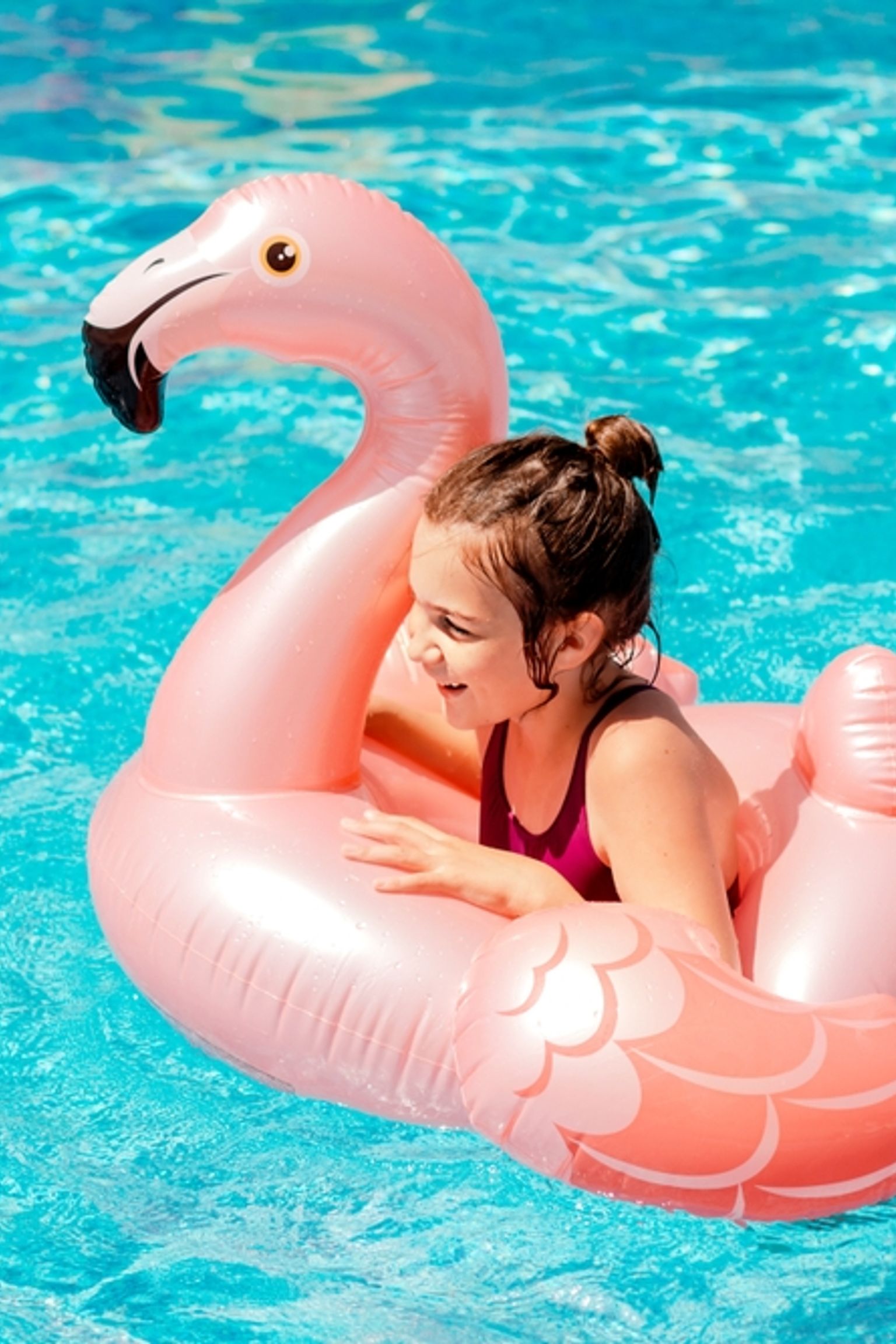 Dziewczyna w różowym flamingu do pływania.