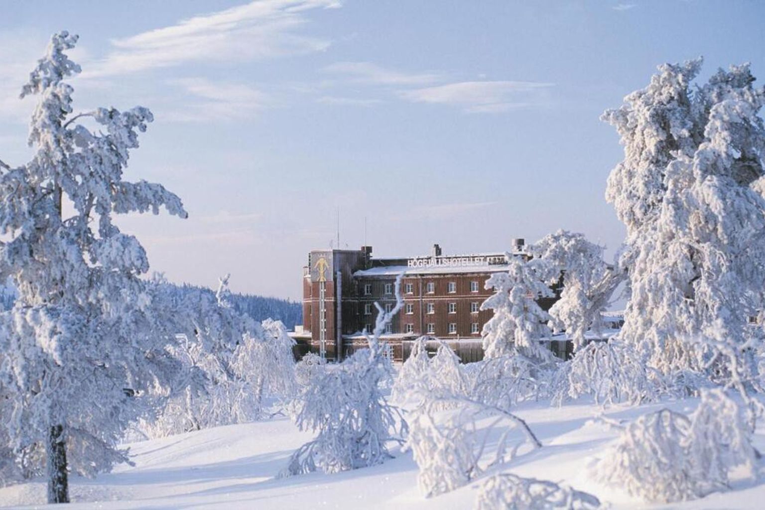 en stor bygning er omgivet af sneklædte træer