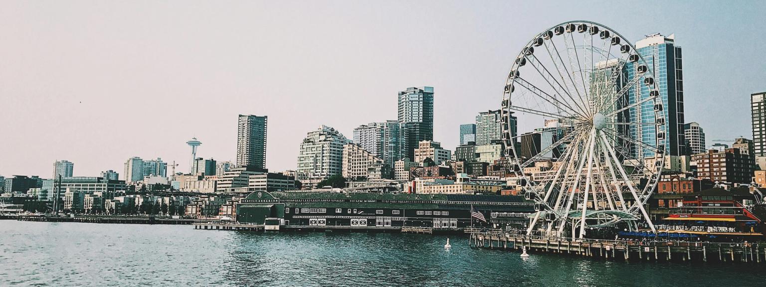 Seattles skyline med Great Wheel og Space Needle set fra vandet.